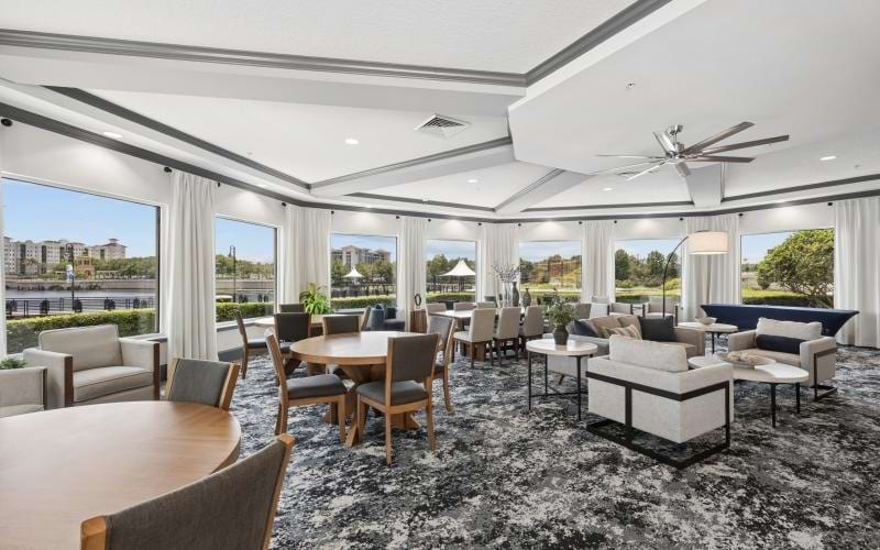 a room with a large window and a large group of tables and chairs