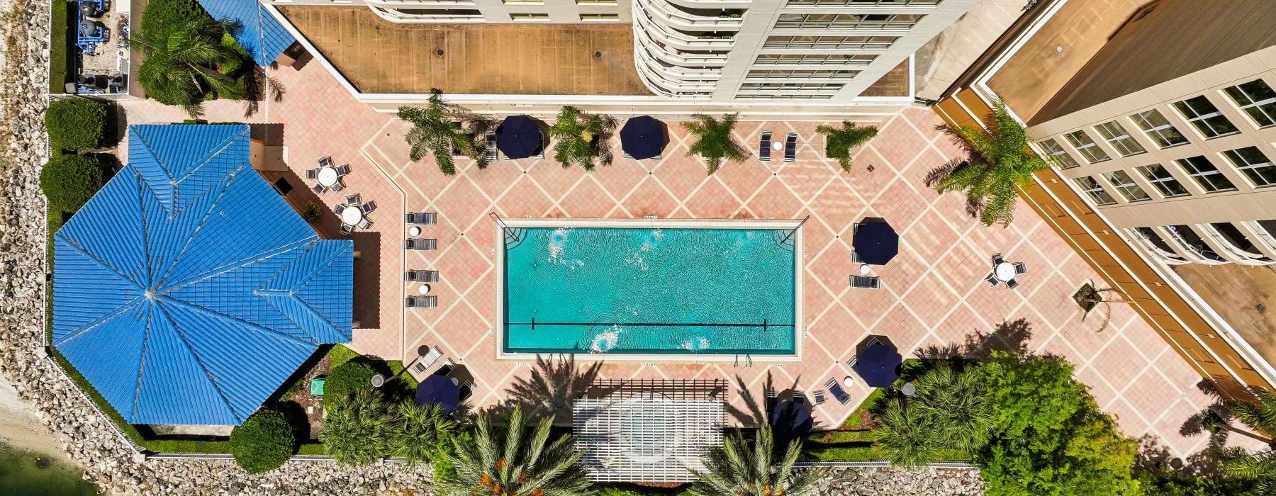 a building with a pool and a large umbrella